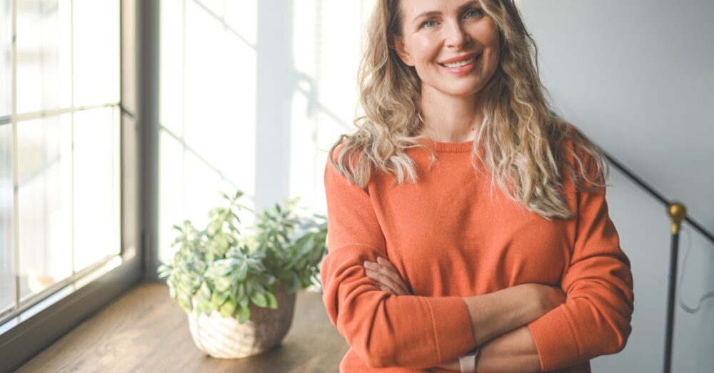 Happy woman with arms crossed smiling confidently